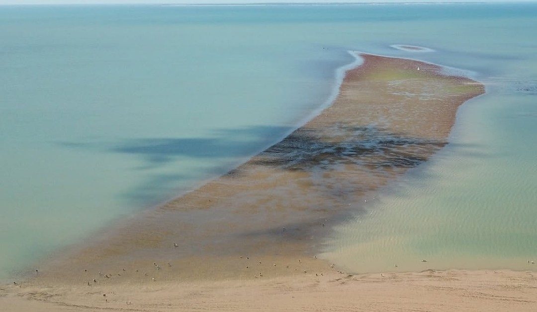 Un banc de sable découvert au milieu d’une eau turquoise
