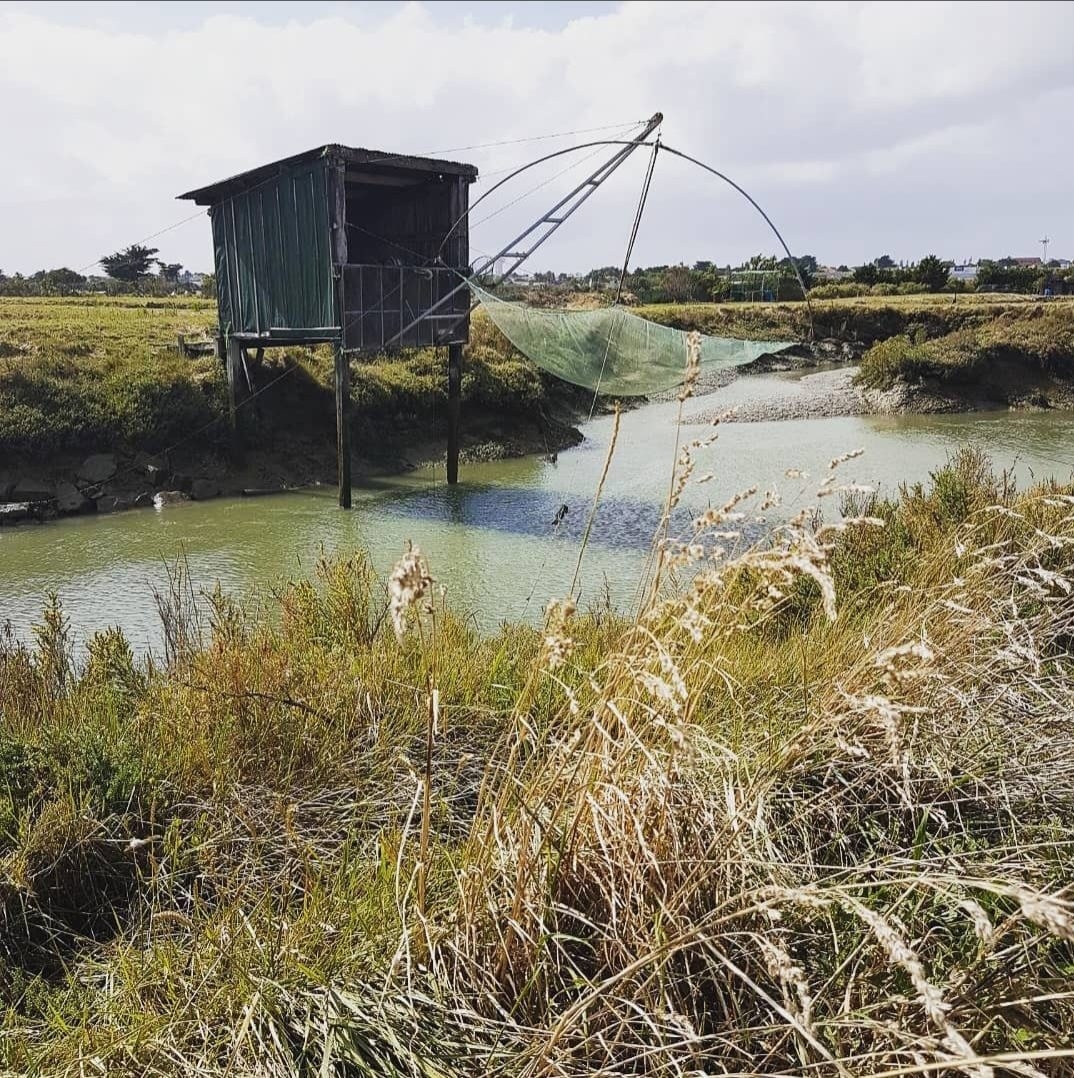 Une cabane de pêche au carrelet au bord d’un canal